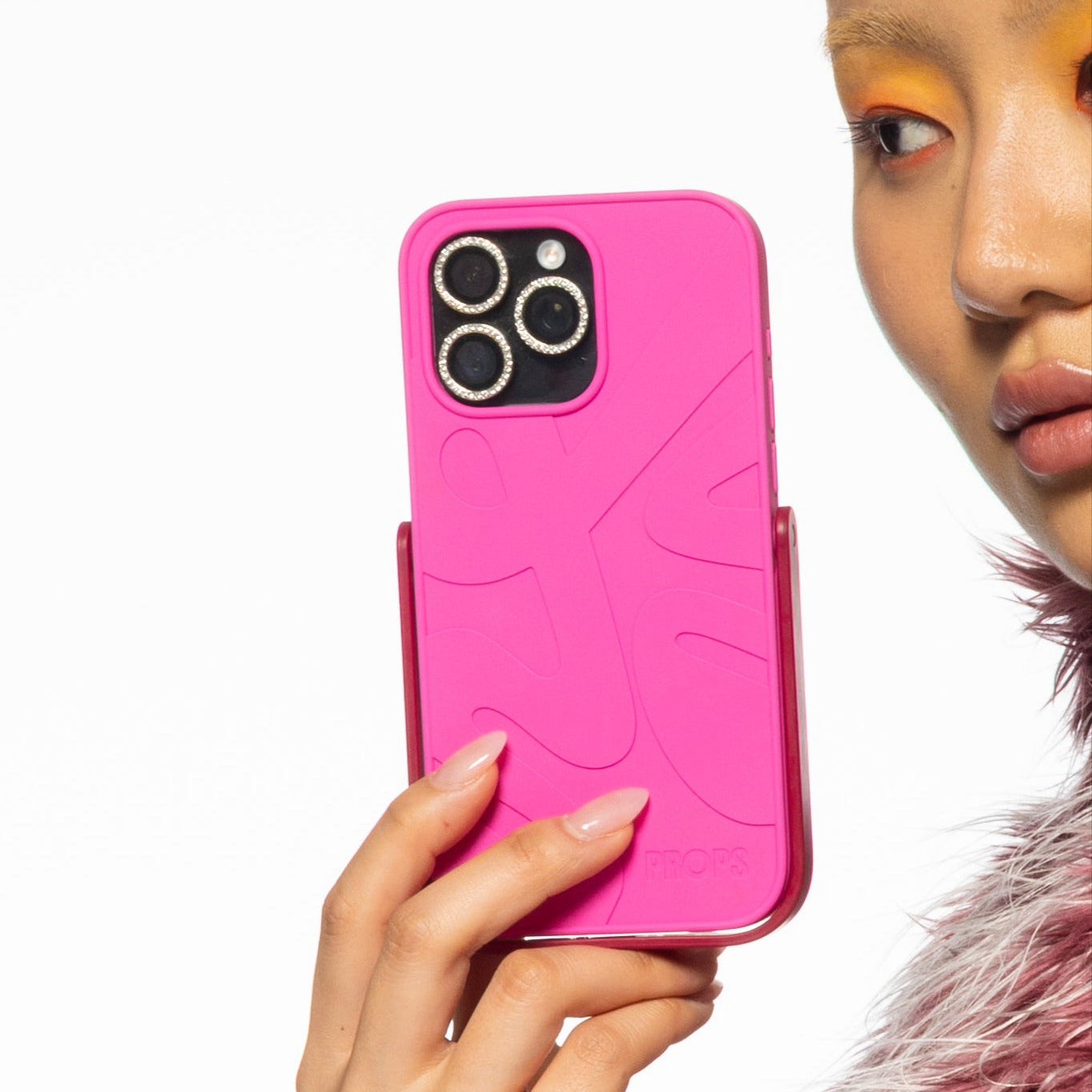 Person holding a pink PROPS phone case with a white background