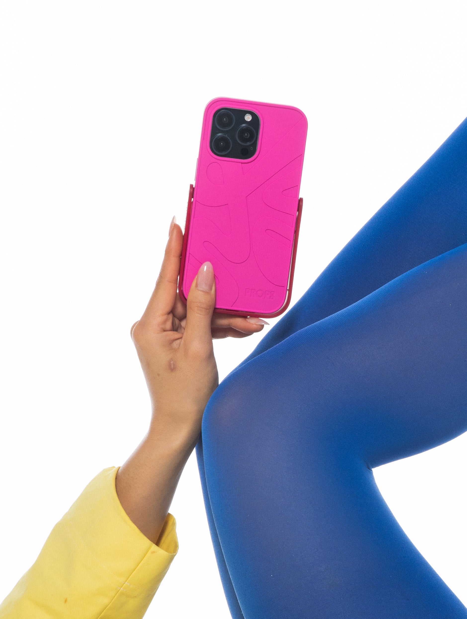 Person holding a pink PROPS phone case with a white background