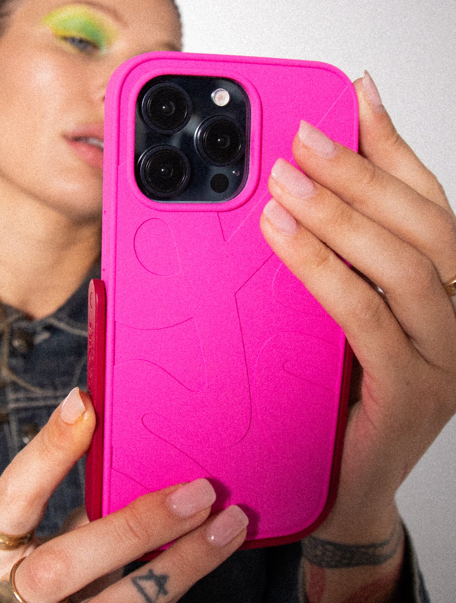 Person holding a pink PROPS phone case with a textured design