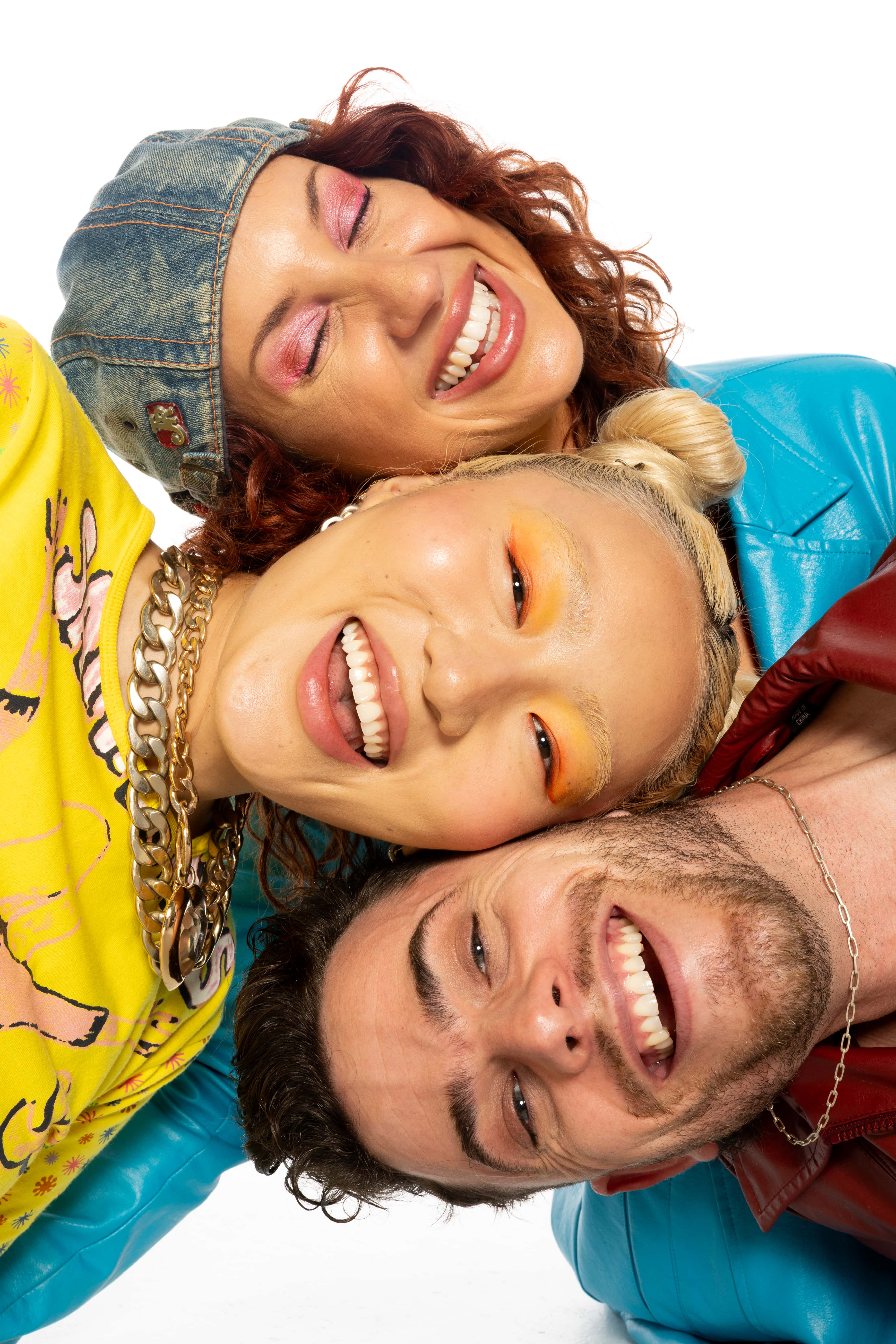 Three people lying on top of each other with a white background