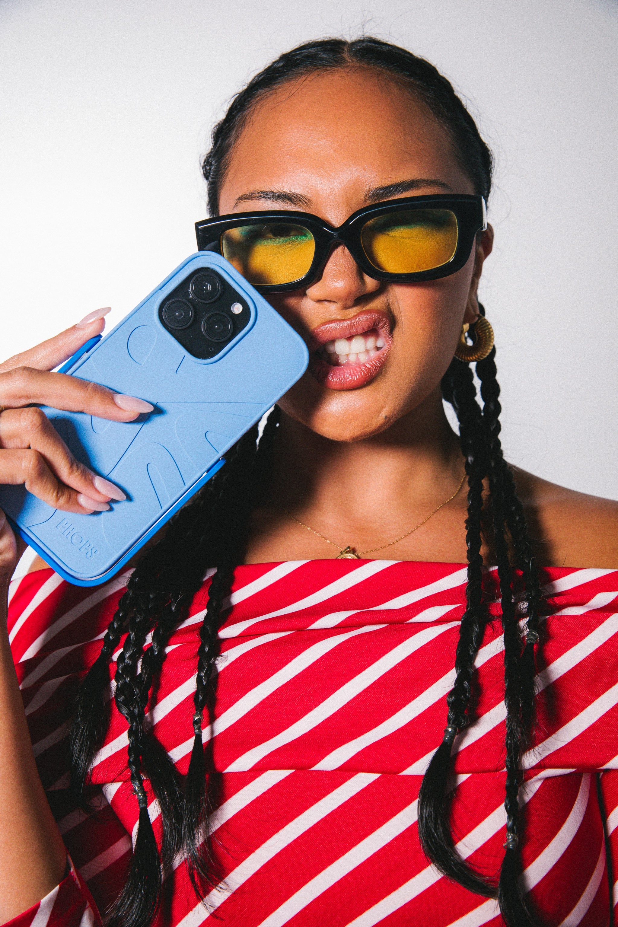 Woman holding an iPhone 15 pro in a blue case with built in stand.